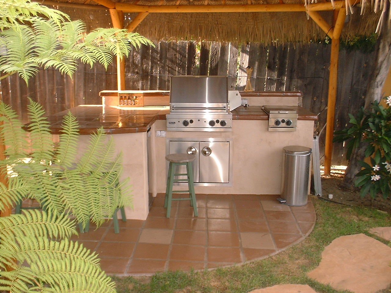 An Outdoor Kitchen Space With Barbeque Stand