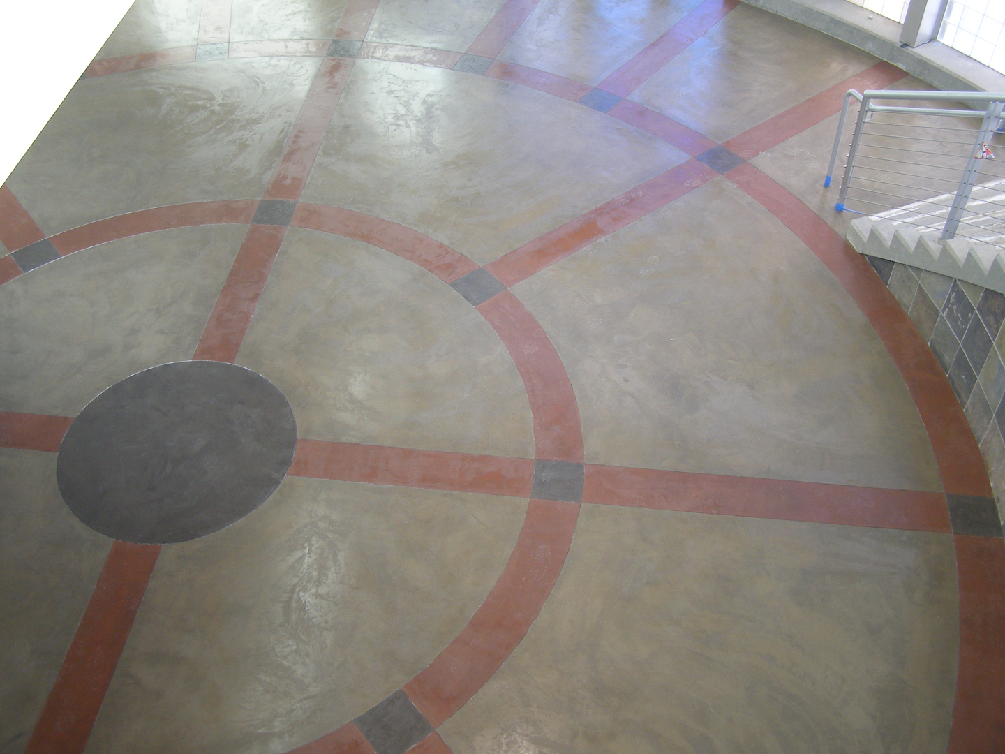 A Concrete Floor WIth Circular Pattern With Red and Black