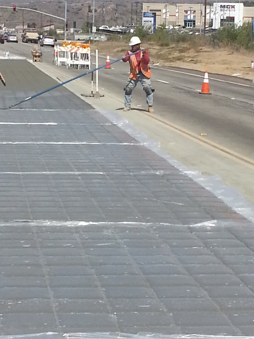 A Man Working on a Concrete Flooring on Road