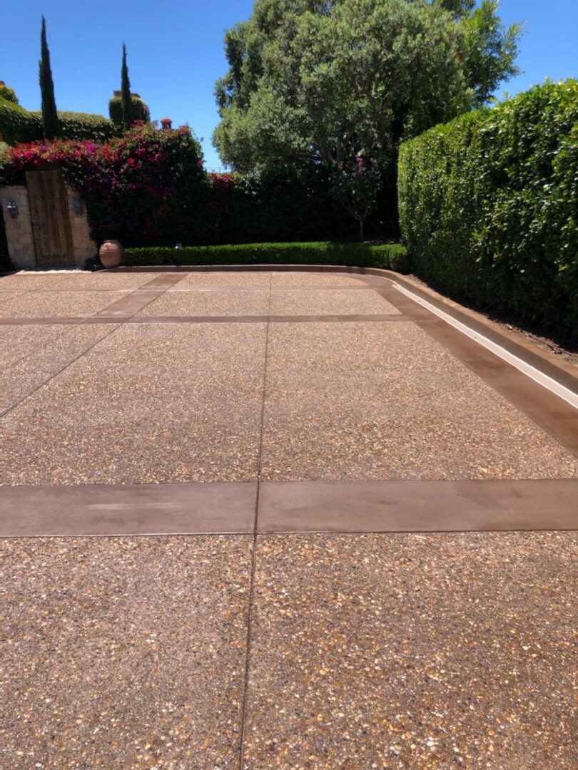 Closeup shot of brown granite tiles beside the garden area