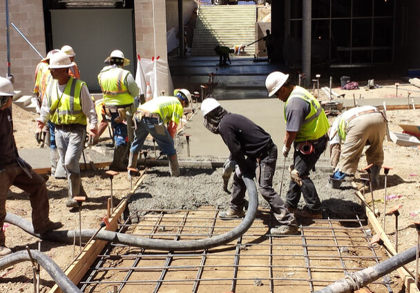 Workers Working on a Concrete Floor Under Construction